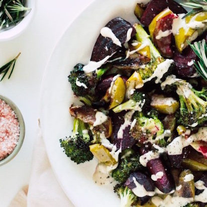 roasted apples, beets and broccoli with herb tahini sauce on a plate