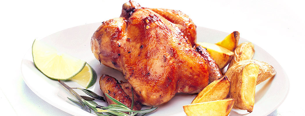 Cornish game hens in a plate with potatoes and limes